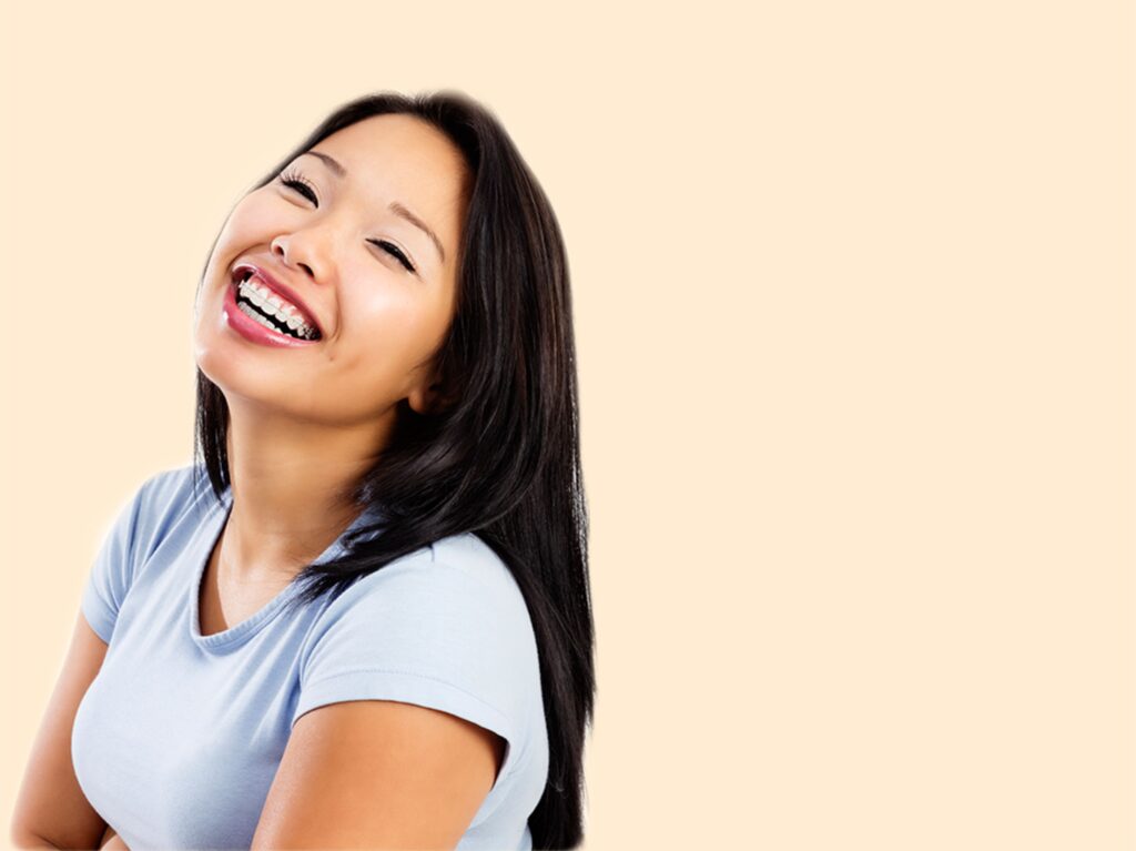 Never too late for adult braces, woman with braces smiling wearing blue shirt, with yellow background, braces at Cool Braces with Dr. Tahir