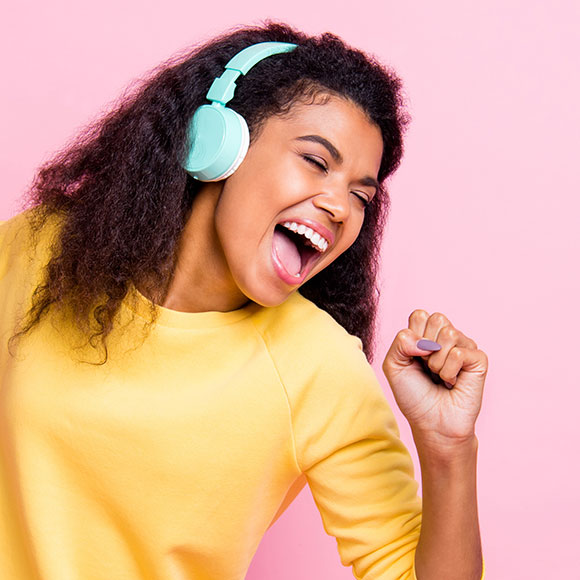 Girl singing into a imaginary microphone while wearing headphones